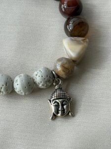 Armband aus weißem Lavastein, rotem gebändertem Achat und facettiertem Onyx mit einem kleinen silberfarbenen Buddha-Anhänger