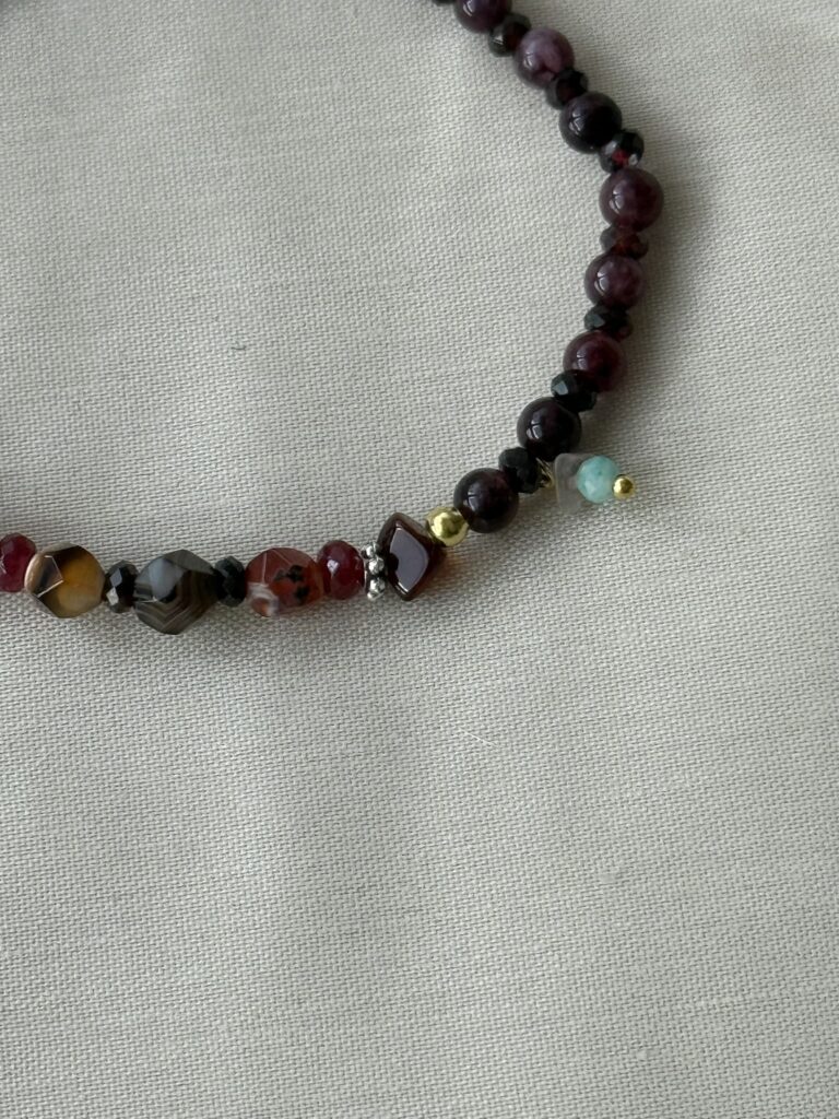 Feines, erdiges Armband aus Granat, Bernstein, orange-braunen Achaten, einem Mini-Bergkristall und einem kleinen Amazonit, kombiniert mit goldenen und silbernen Elementen.