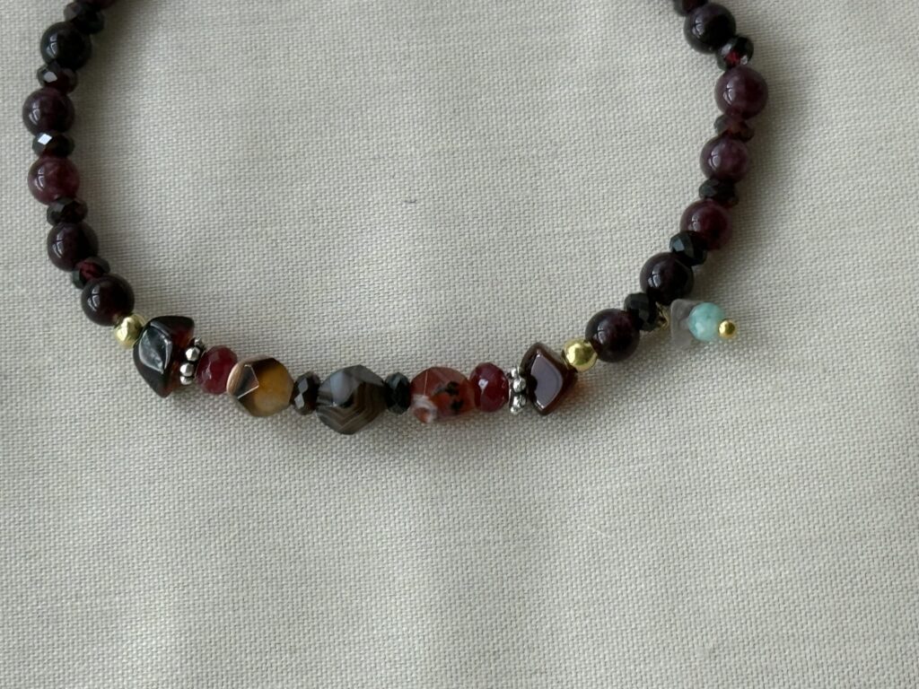 Feines, erdiges Armband aus Granat, Bernstein, orange-braunen Achaten, einem Mini-Bergkristall und einem kleinen Amazonit, kombiniert mit goldenen und silbernen Elementen.