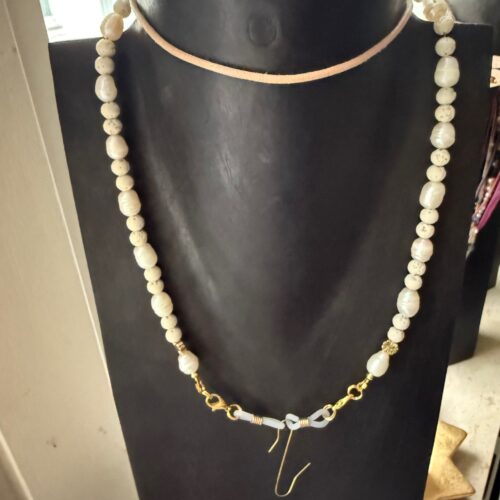 Healykette aus weißer Lava und Süßwasserperlen, gehalten von einer feinen Lederkette. Brillenhalterung zur Befestigung des Healy.